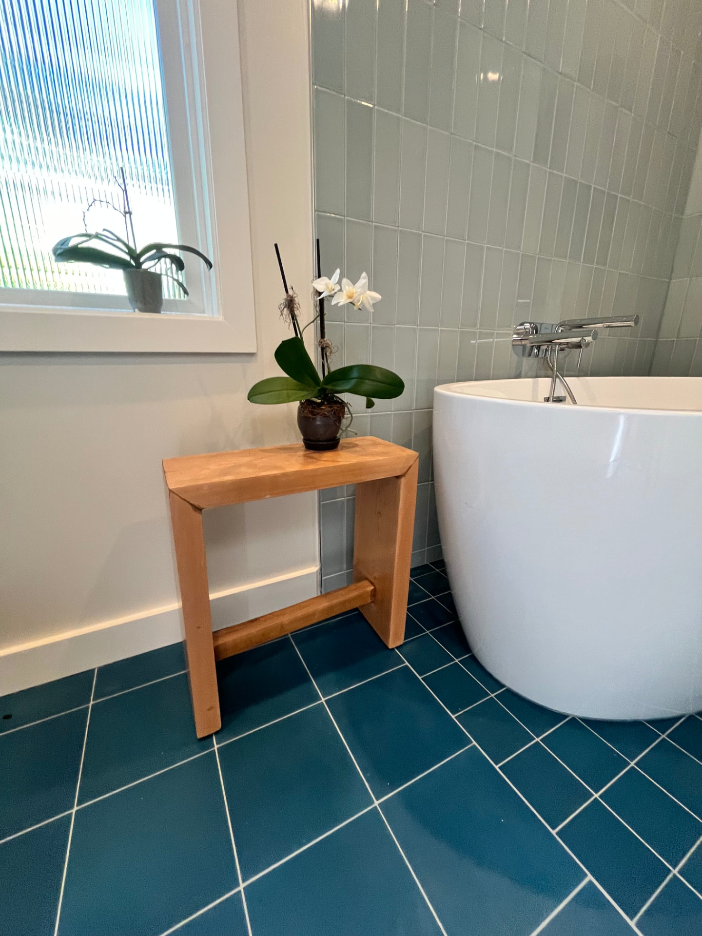 Bath table beside soaking tub with orchid on top