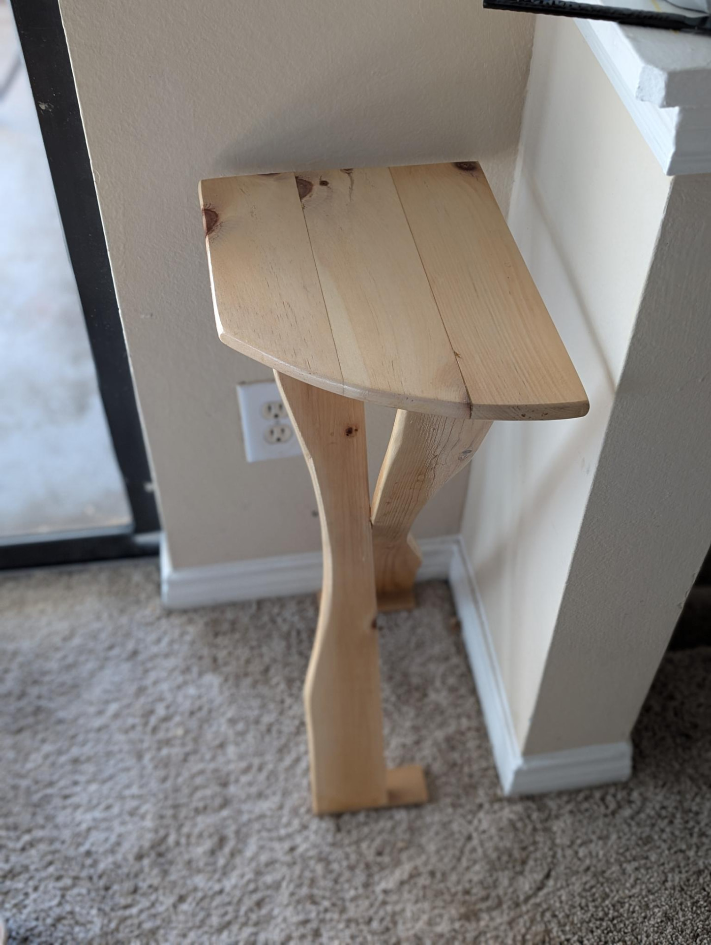 End table tucked into a corner, side view of curved leg